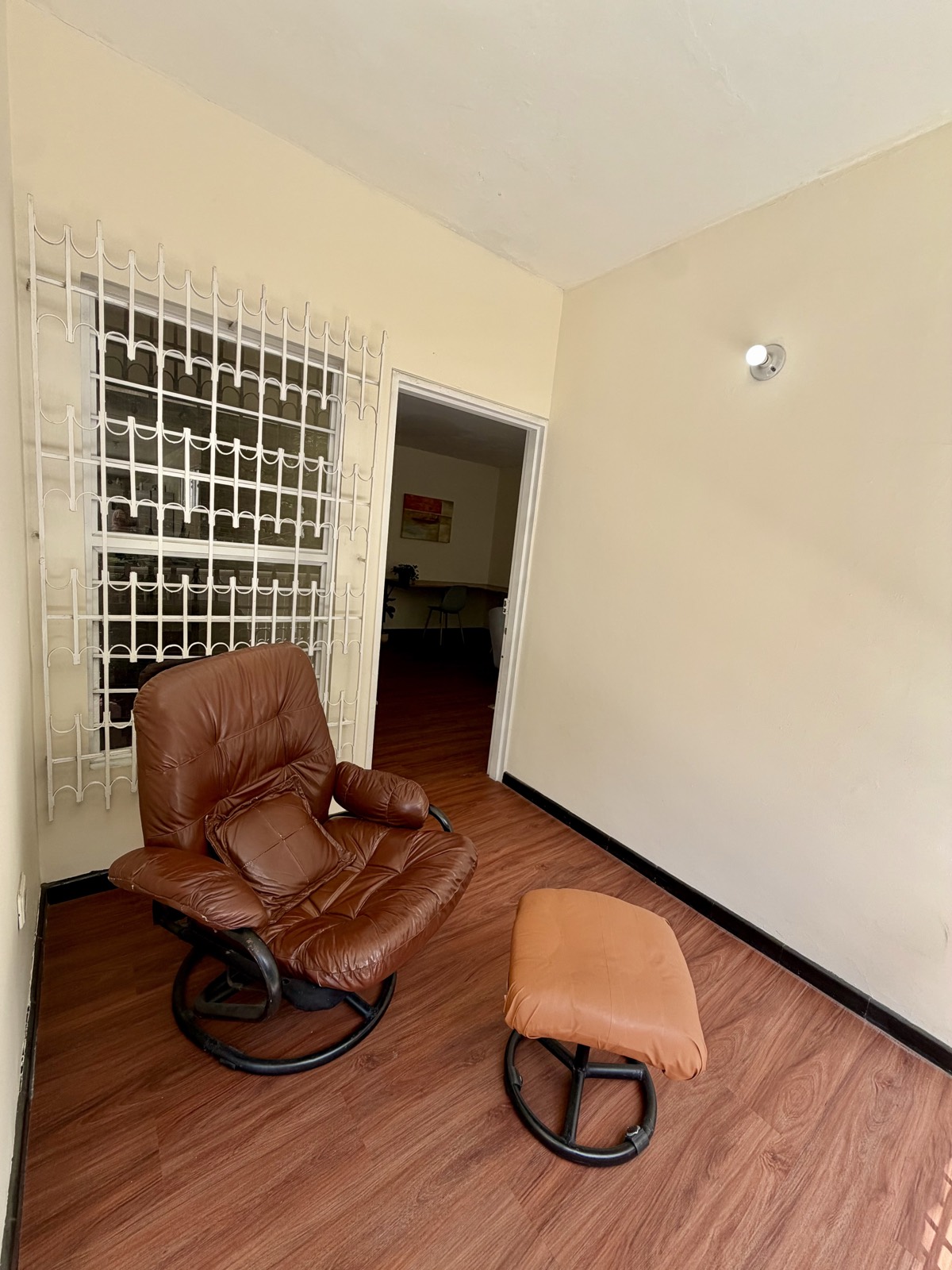 Rincón de lectura con sillón de cuero en las zonas comunes